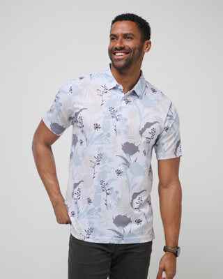 A man wearing a short-sleeved floral and striped pattern polo shirt with a built-in collar.