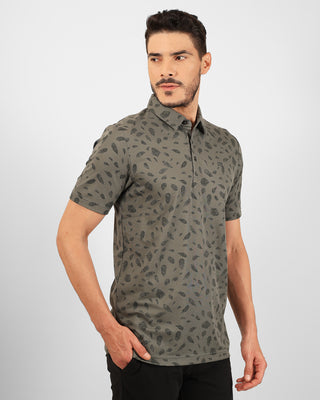 Man wearing a patterned green shirt on a plain background