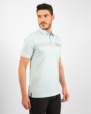 Man wearing a light blue polo shirt with a subtle pattern on a white background