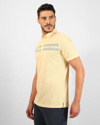 Man wearing a light yellow polo shirt with a subtle pattern on a plain background